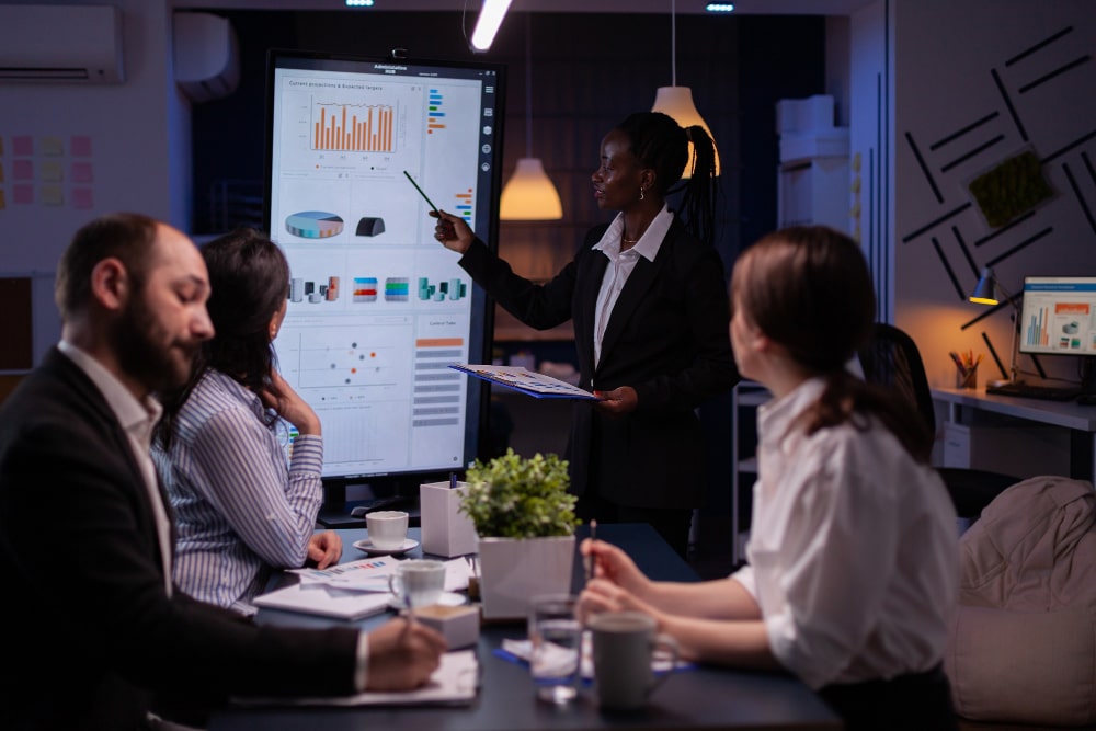 workaholic-african-american-leader-standing-front-presentation-monitor-explaining-marketing-pr-min