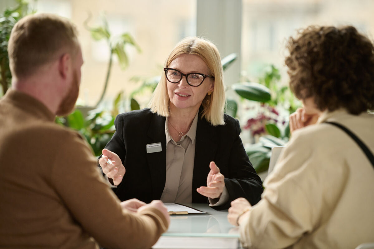Portrait of female insurance broker consulting couple